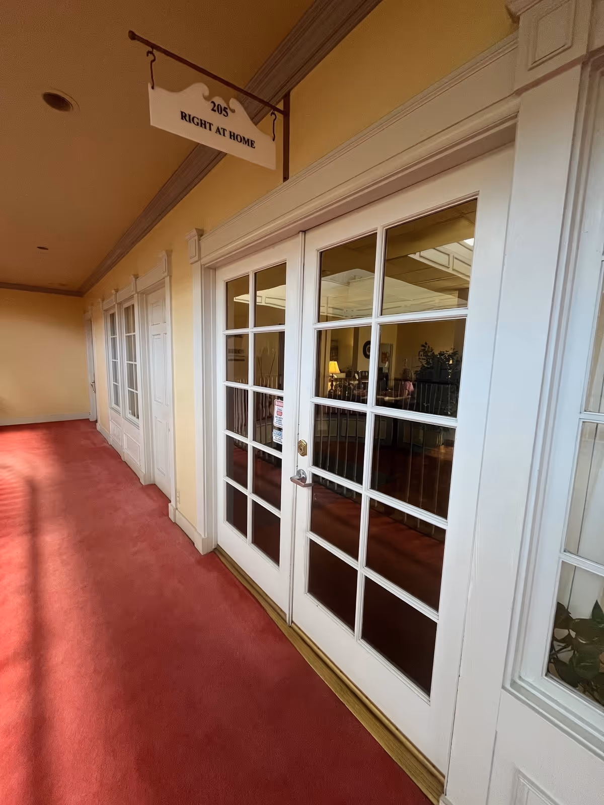 Interior corridor with glass-paneled doors and a Right at Home sign