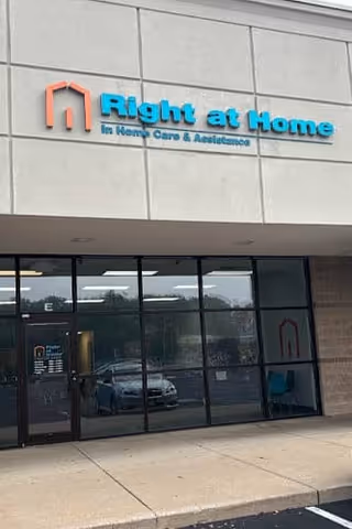 Exterior view of a Right at Home storefront with glass doors and blue signage.