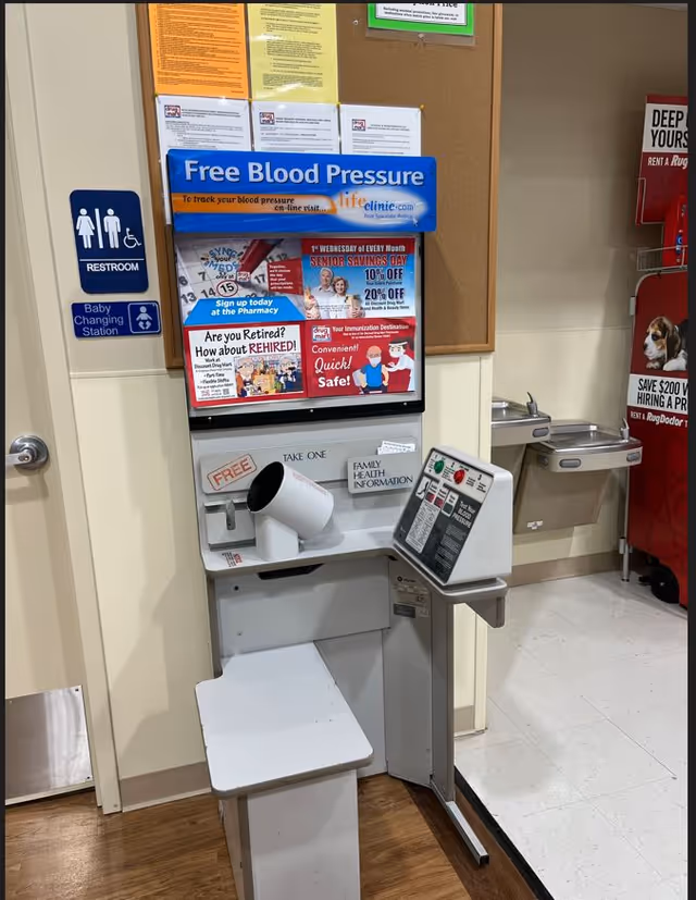 Interior view of a Discount Drug Mart with a free blood pressure station and posters.