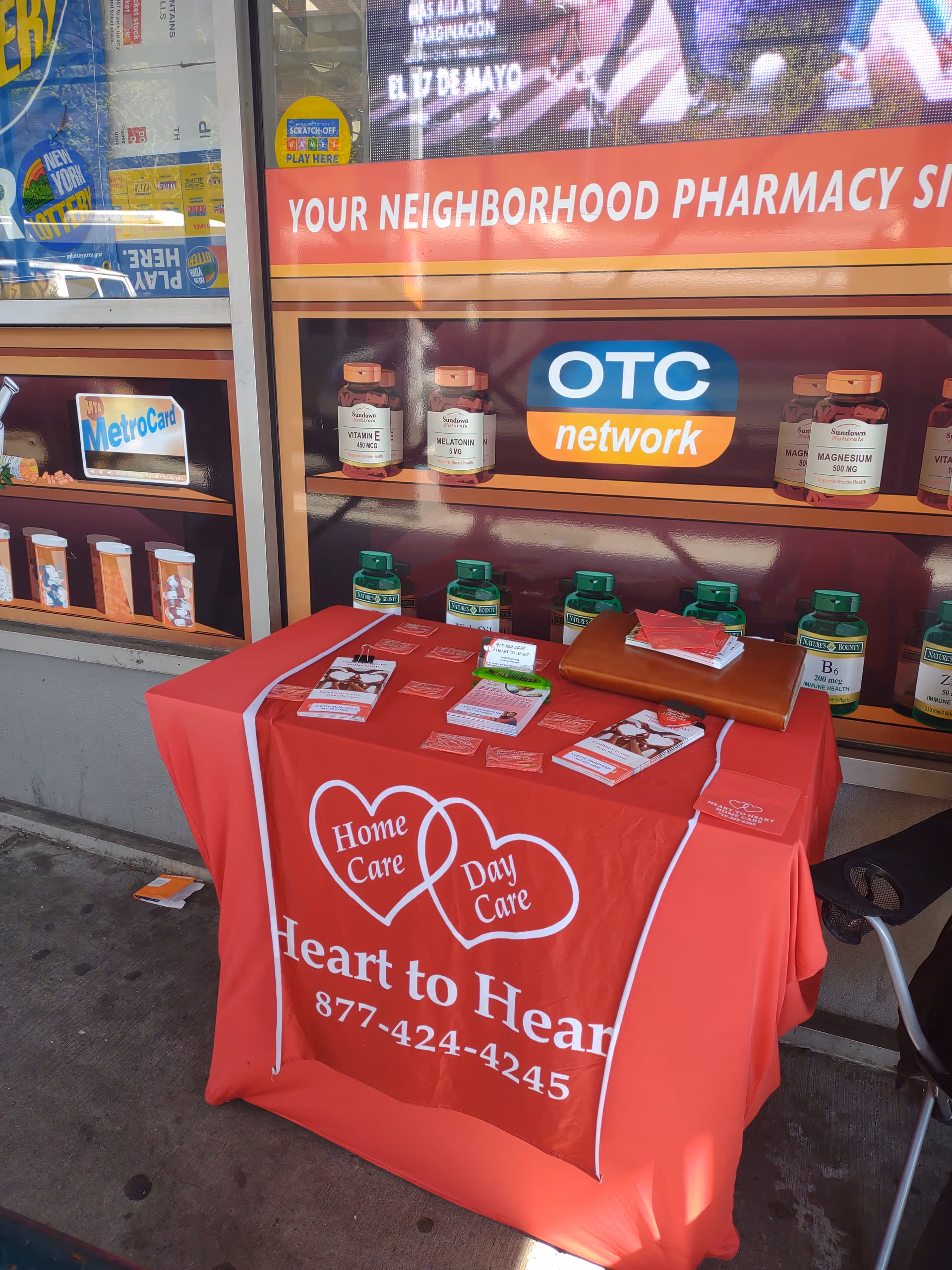 Red promotional table for Heart to Heart Home Care outside storefront.