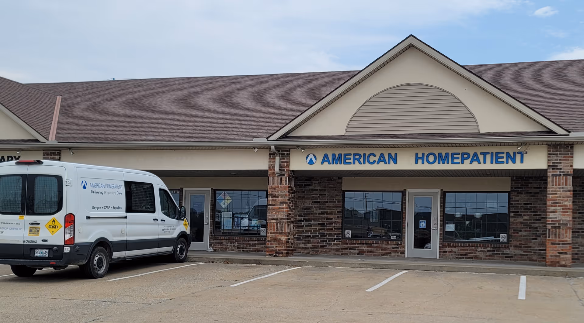 Exterior of American HomePatient facility with a white delivery van parked in front.