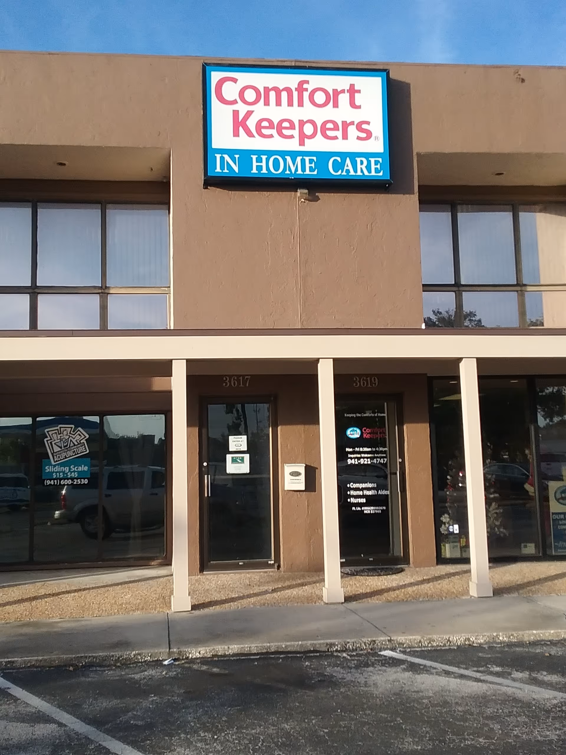 Front view of Comfort Keepers In Home Care storefront with entrance doors and sign.