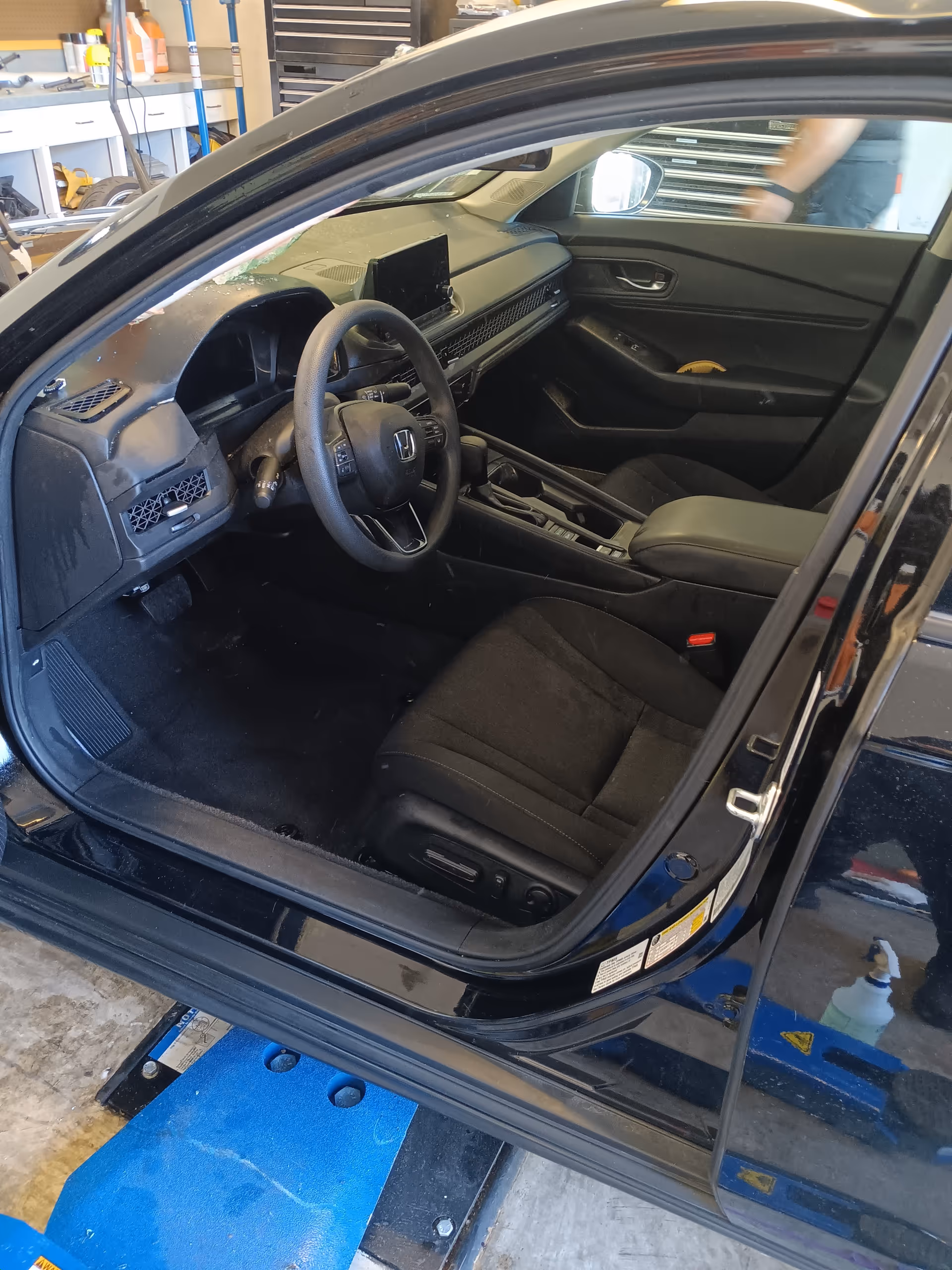 Open car interior with dashboard, steering wheel, and front seats visible inside a vehicle.