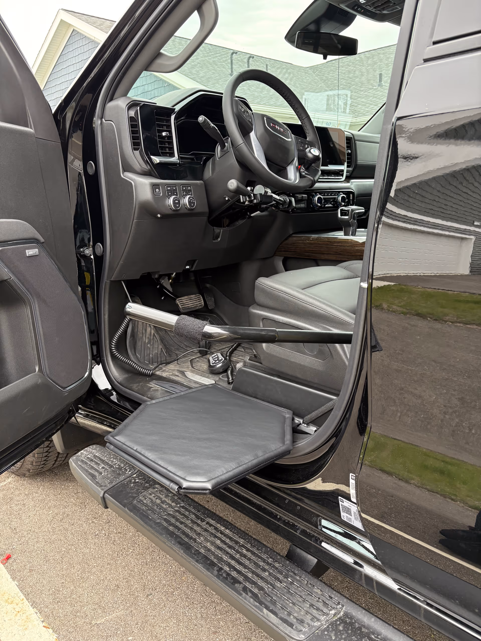Interior of a black mobility vehicle with lowered step and accessible controls.